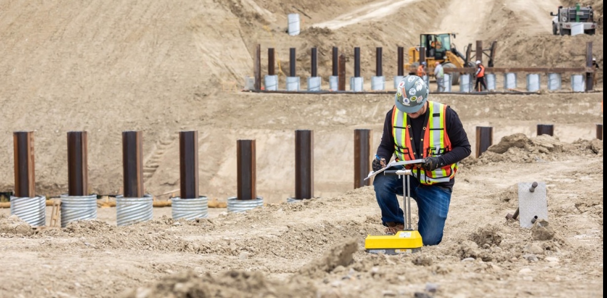 a man in a safety vest and helmet working on a construction site