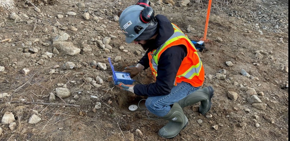 a man in a safety vest and helmet working on a device