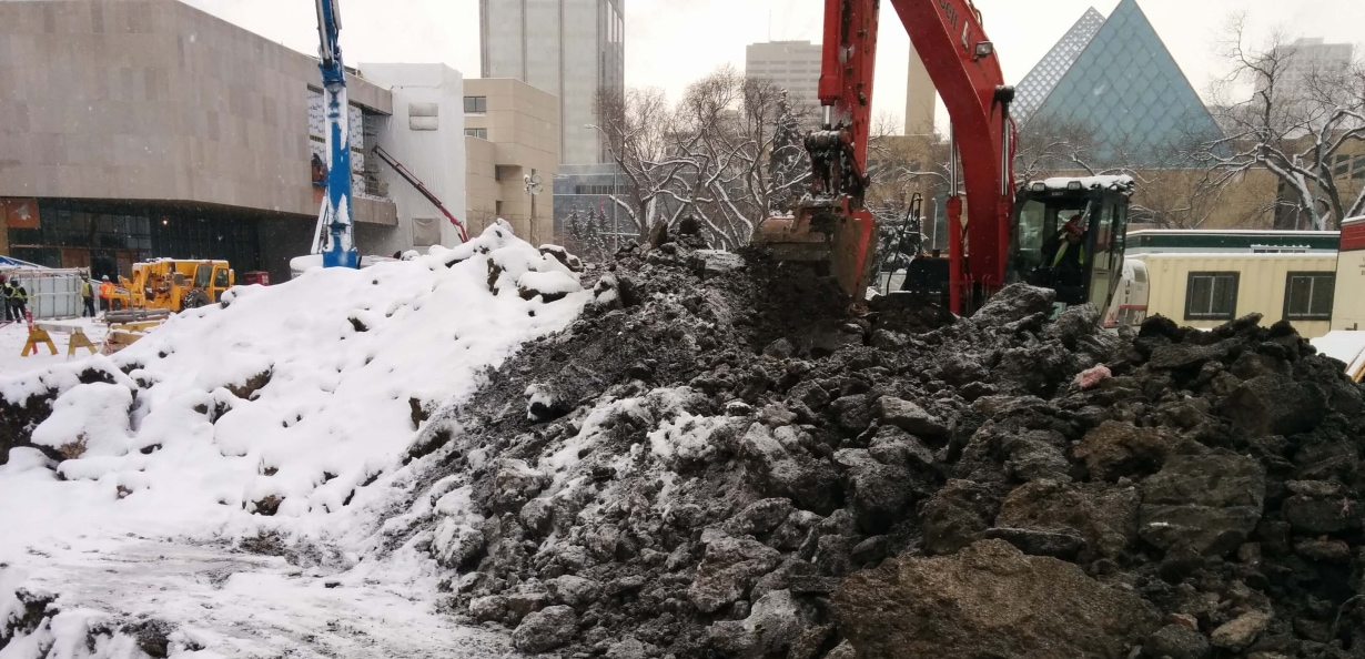 a construction site with a pile of dirt and snow